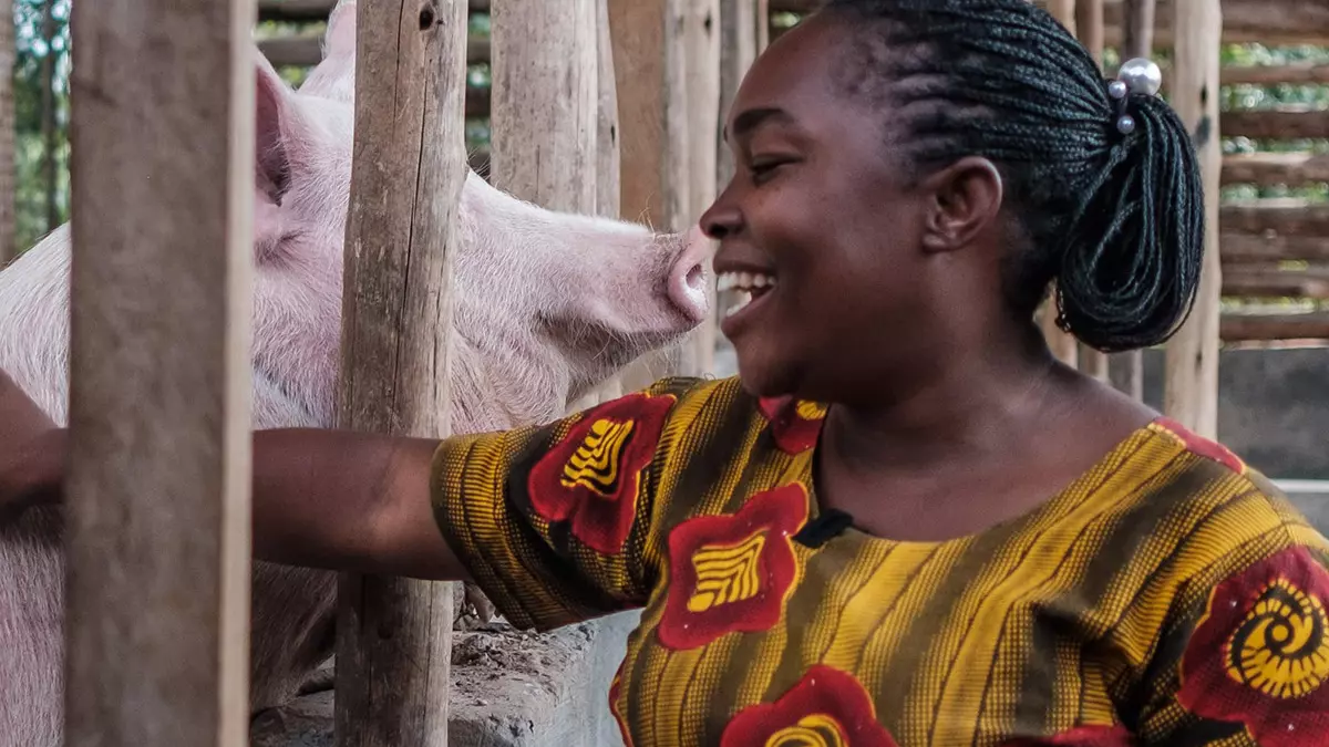 Woman with pig in pen Sumy Sudarni